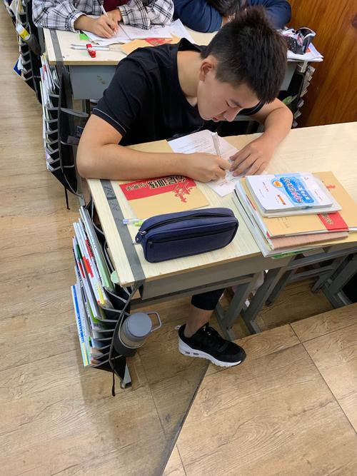 高中生蹲在玄关拿着地理答题卡场景