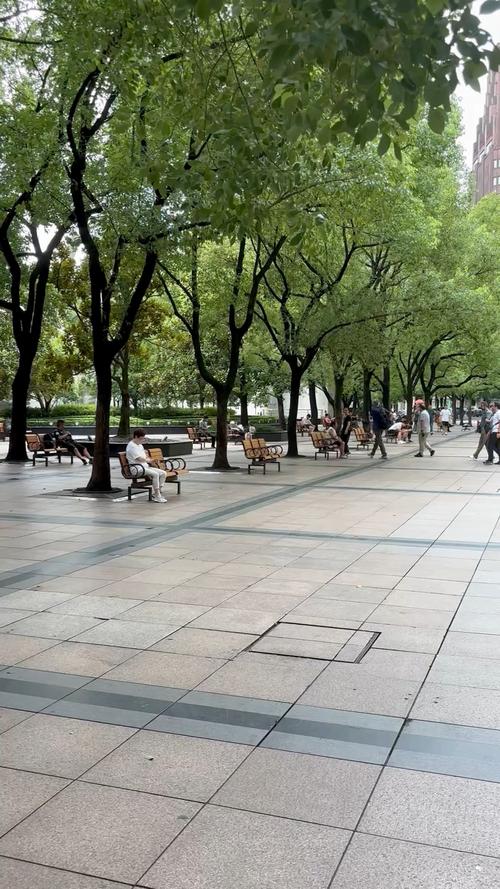 城市公园饭后慢走人群实拍图