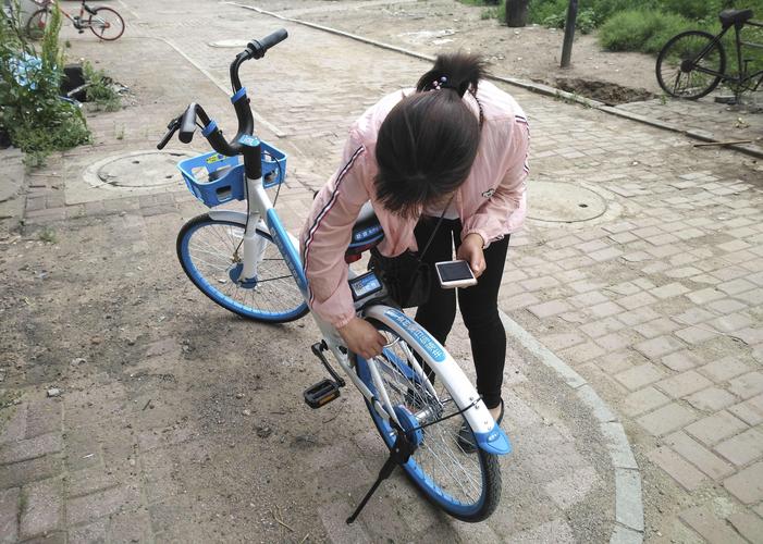 春天路边共享单车车篮放着打开播客的手机