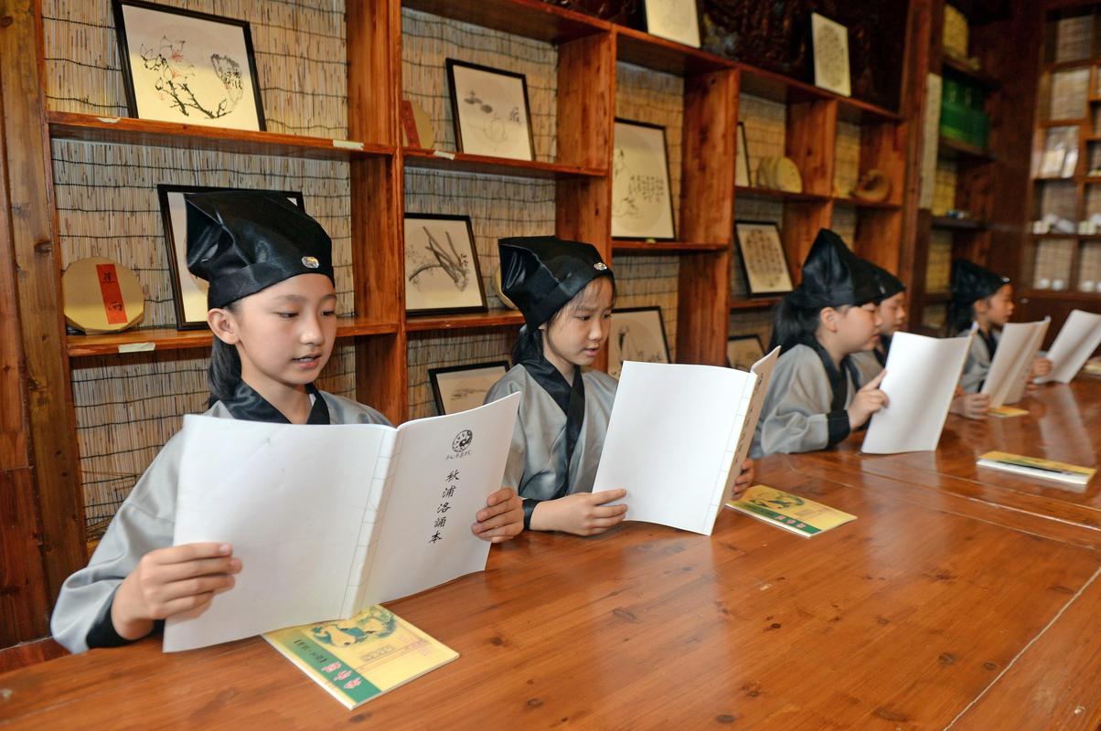 小学生身穿汉服在古色古香教室诵读论语实景