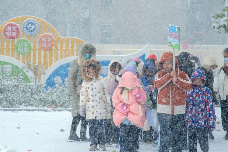 冬日校园走廊上学生趴在栏杆看雪的场景