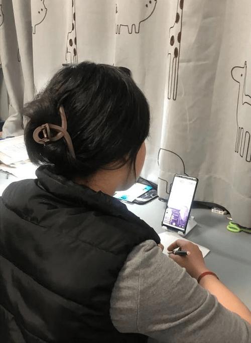 小学家长会后排独坐看手机的父亲