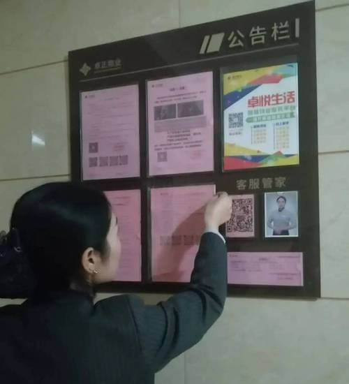 物业人员在楼道张贴装修注意事项公告单