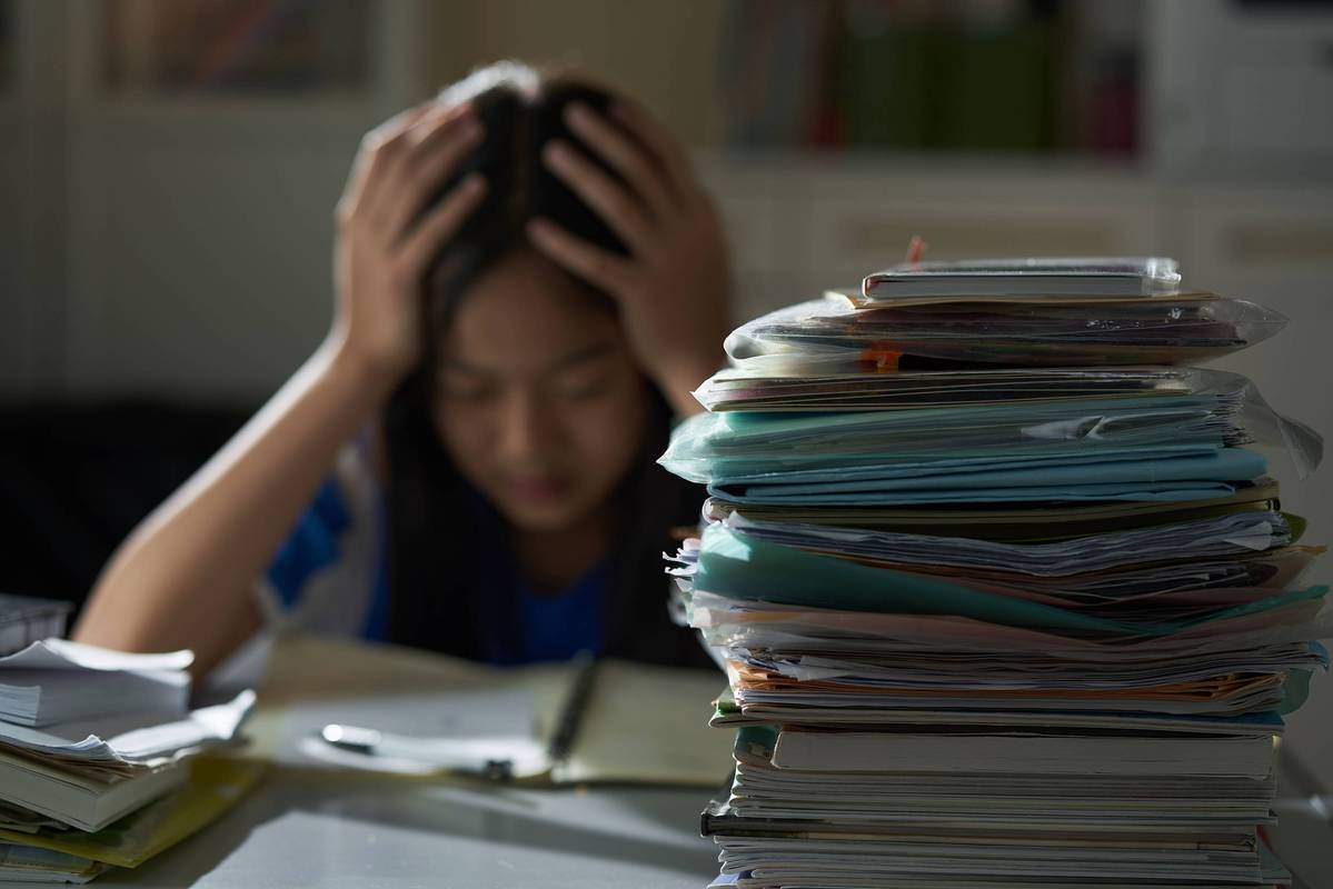 迷茫学生面对满桌证书陷入沉思