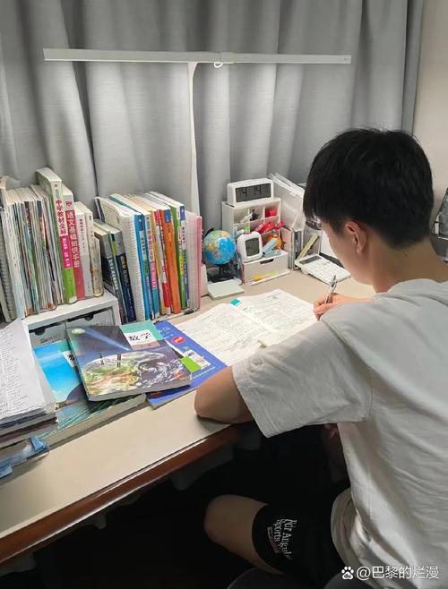 书桌上孩子写作业旁边大人看书的并排背影