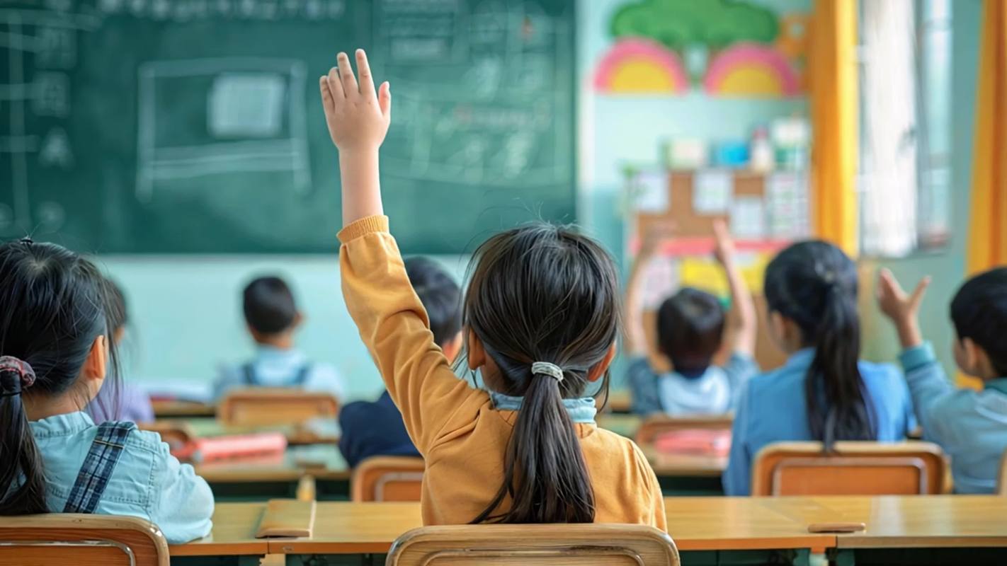 小学教室自习课女生高高举手提问的侧影