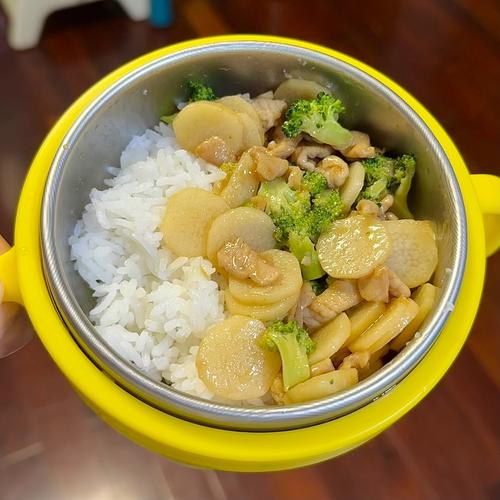 妈妈给孩子盛饭时在白米饭中搭配蒸山药块的日常居家场景