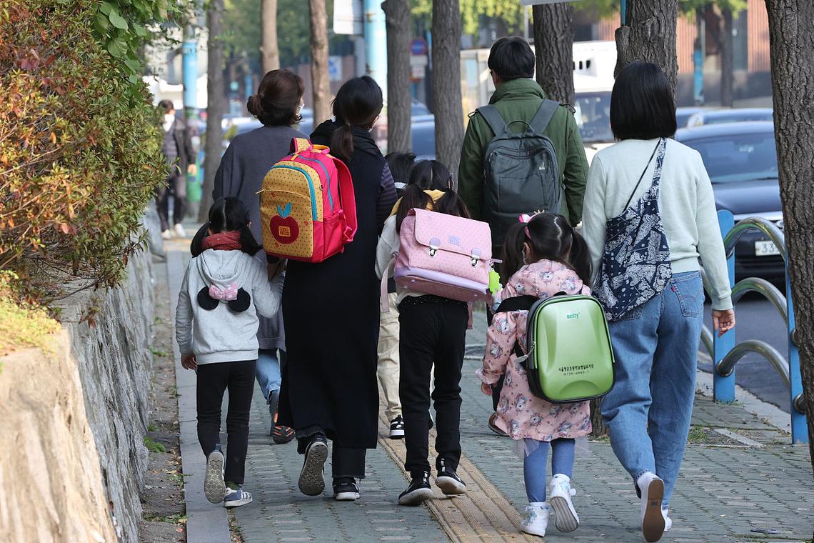 小学家长校门口接娃催背单词场景