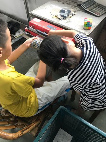 两个孩子一起帮爸爸整理工业工具车间场景图