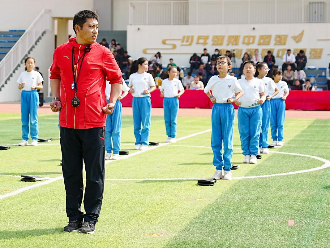 小学操场穿蓝校服男孩接力赛后蹲地哭泣场景