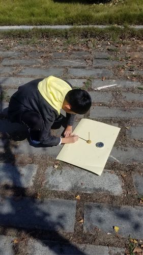 小学生在小区空地上用粉笔描自己的影子测量夹角