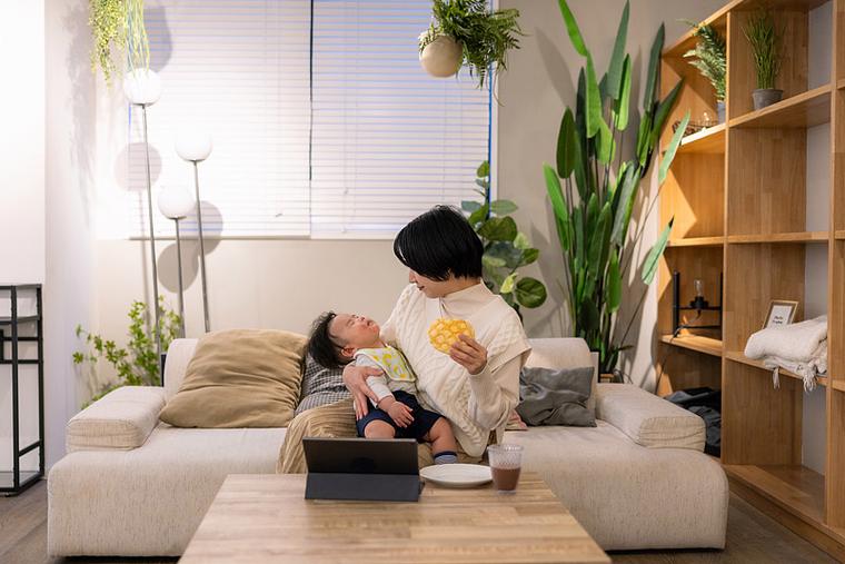 新手妈妈凌晨抱早醒宝宝坐在客厅照片
