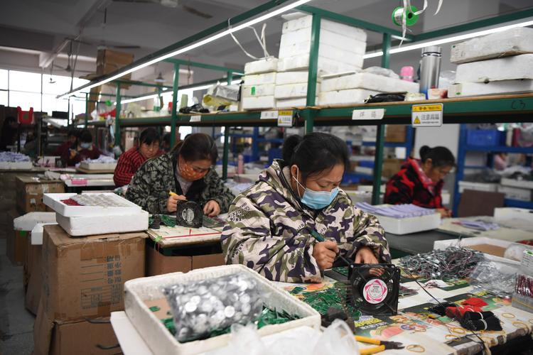 制造业车间工人对着手机银行算账的实拍图