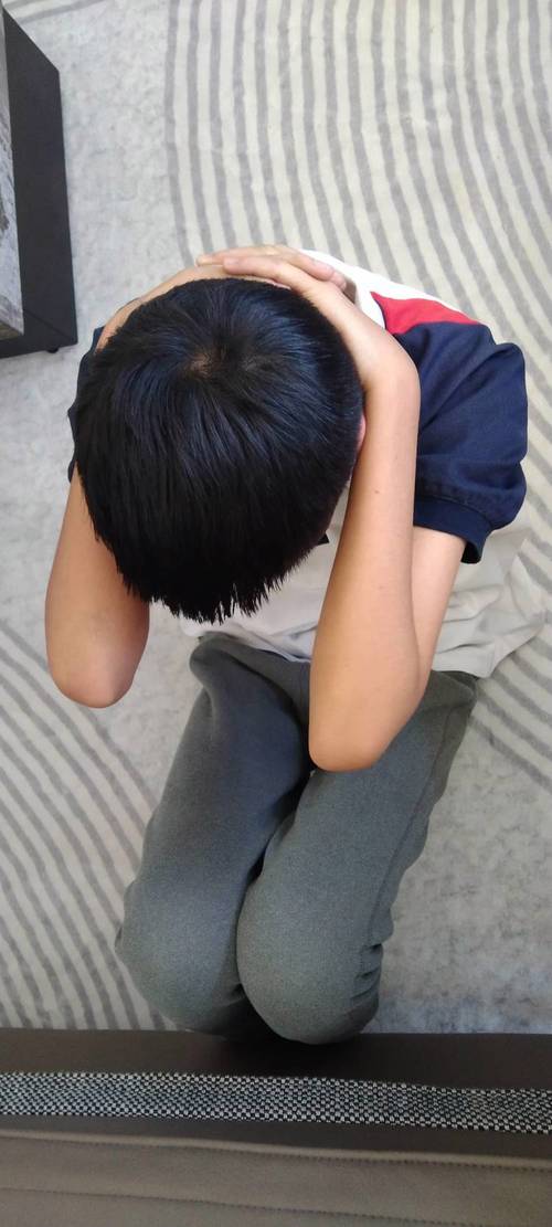 小学传达室门口攥拳头闹情绪的小男孩
