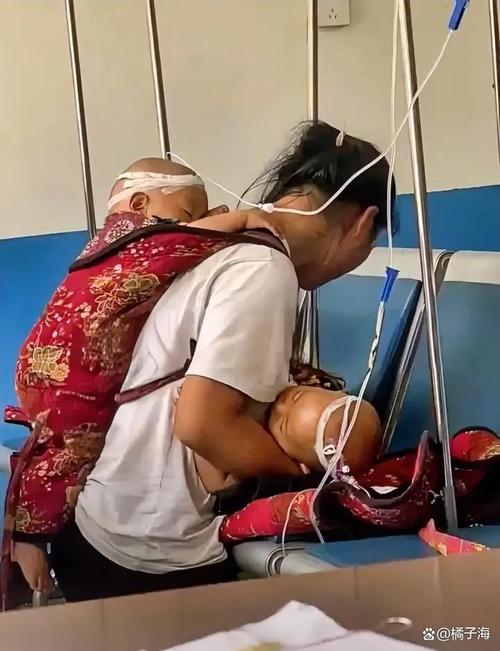 单亲母亲抱着生病的孩子在急诊室输液