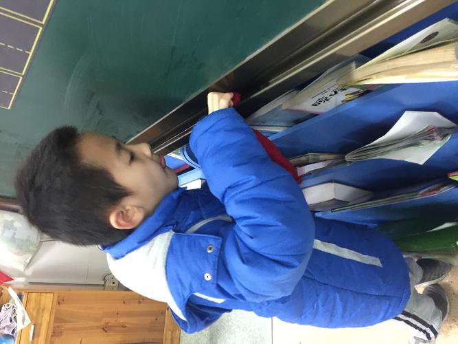小学教室门框旁站着的攥橡皮小男孩