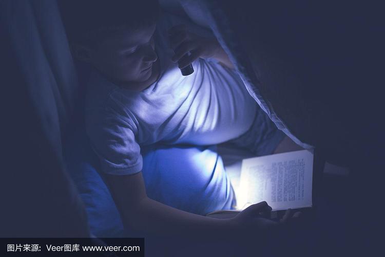孩子深夜躲在被子里打手电筒看书