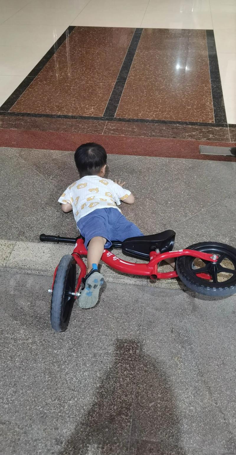 孩子学习骑自行车摔倒后重新骑上的瞬间