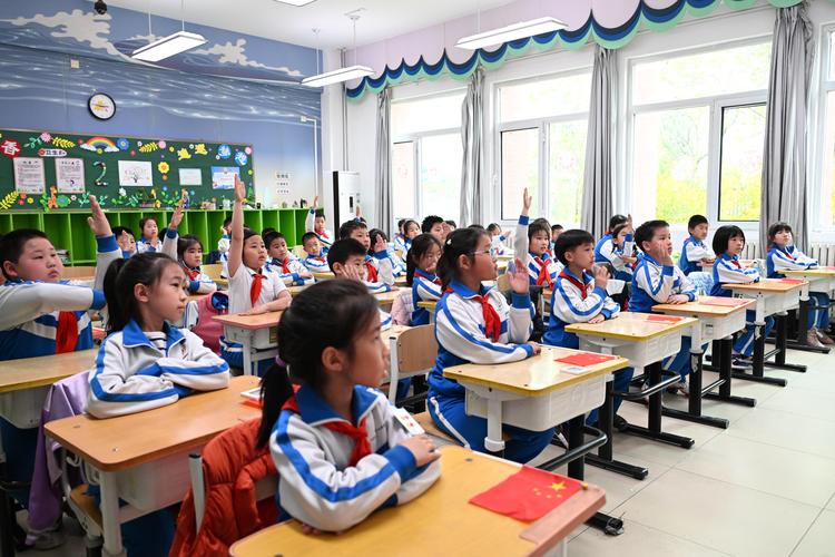 小学课堂孩子们踊跃举手互动的场景