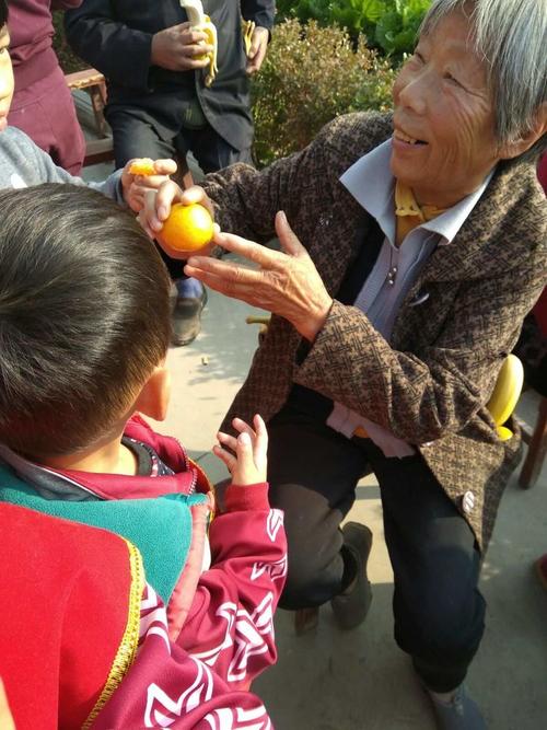 小学门口老人接放学攥着剥好的橘子