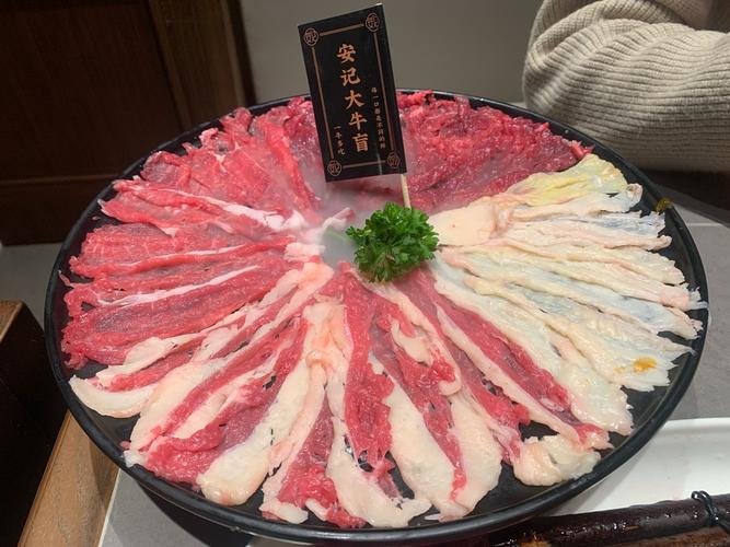 火锅店内服务生上菜嫩牛肉拼盘