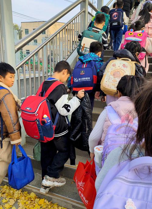 拎着辅导教材书包的小学生站在单元楼门口