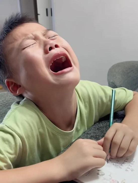 小学生低头看试卷流泪特写