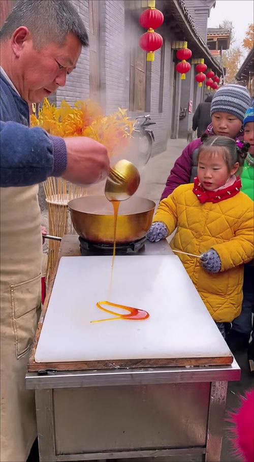 街头糖画师傅给围观的小朋友递刚刮下来的糖稀小糖豆