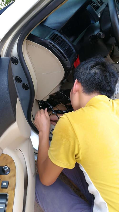 车主蹲在汽车后排座椅下方听燃油泵工作声音