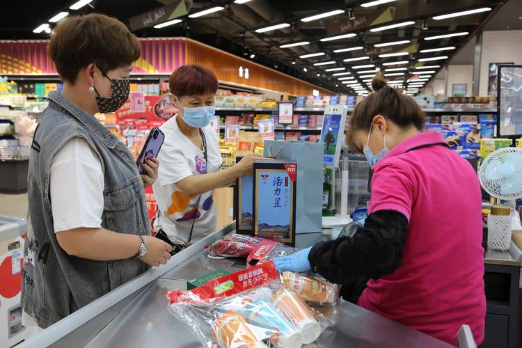超市自助收银区老年顾客被引导员协助操作
