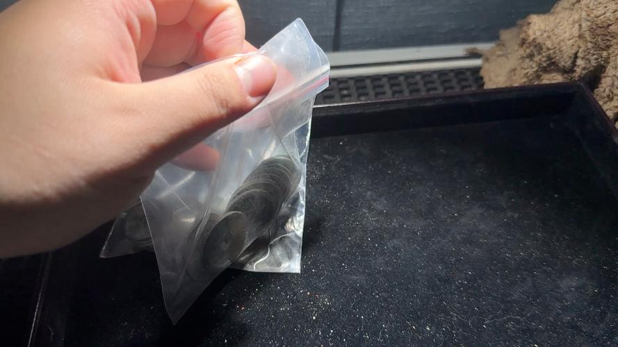 用硬币刮真空收纳袋密封条的手部特写