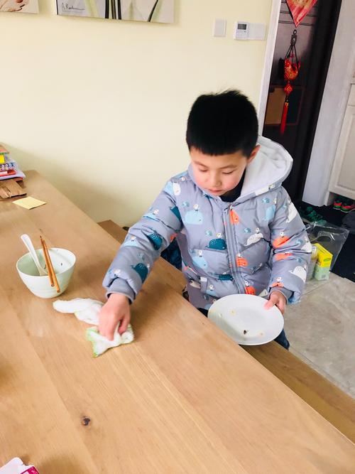 亲子家庭餐桌七岁男孩擦桌子场景