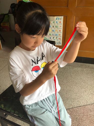 乡村小学女孩手腕上绑着旧橡皮筋的特写