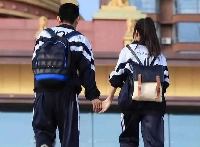 攥着校服衣角跟男同学说话的小学低年级女生