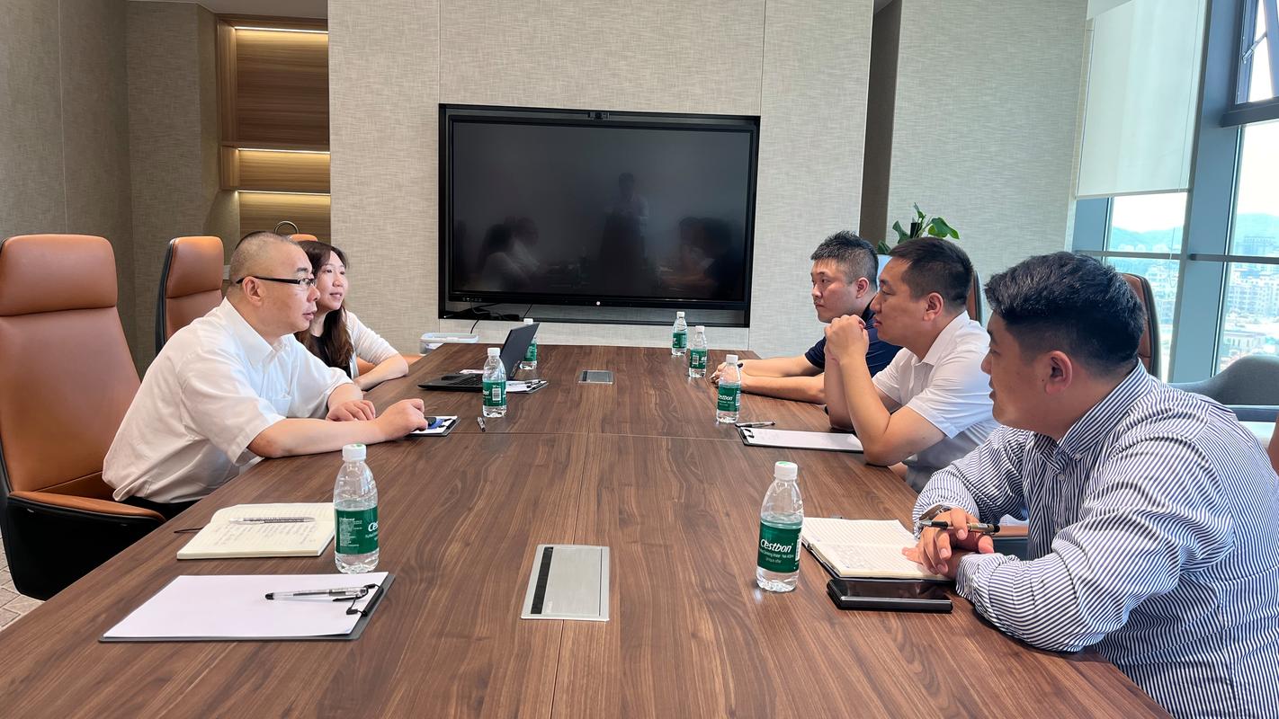 管理者在会议室对着绩效表和下属严肃谈话的真实办公场景