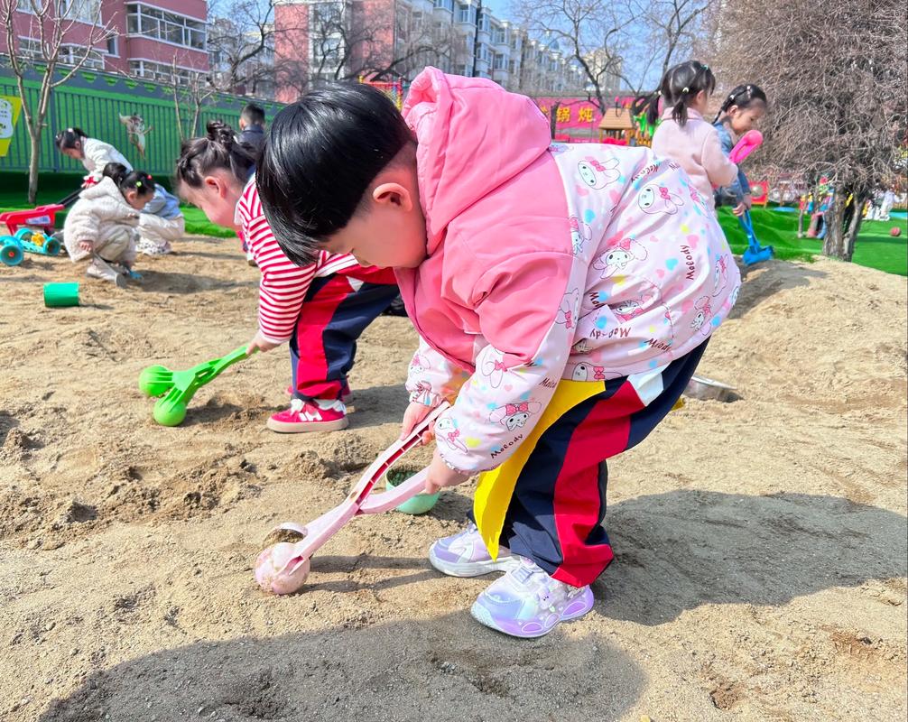 幼儿在公园泥土堆玩挖沙子场景