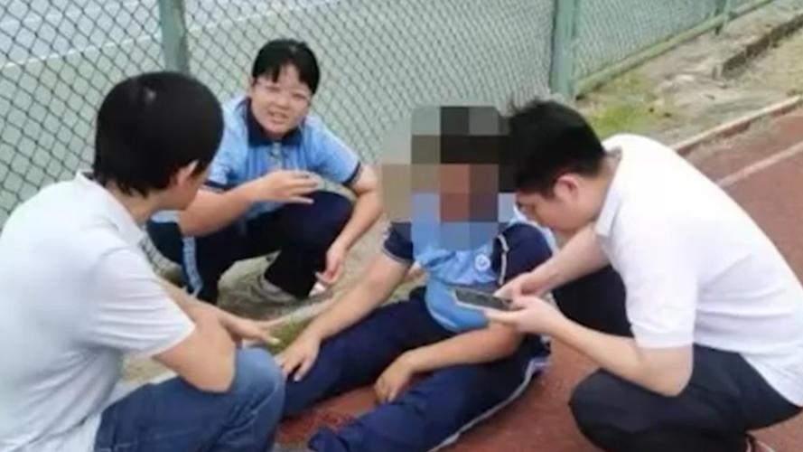 中学走廊穿蓝白校服的男生攥着东西躲墙根的实拍