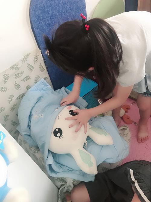 幼儿给玩偶讲绘本的居家场景