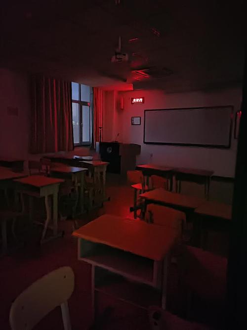 夜晚小学走廊教师靠在消防栓上发呆的侧影