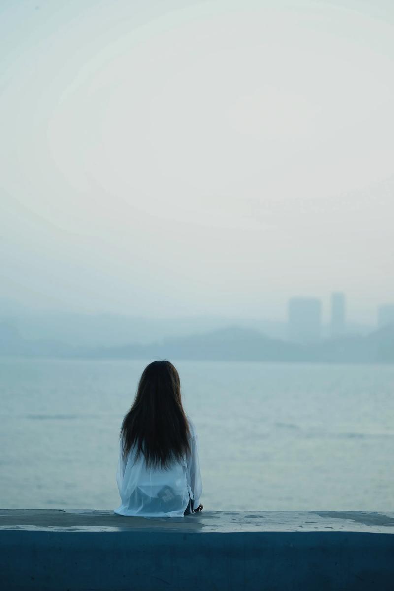 失恋后独自看海回忆过去的女性背影