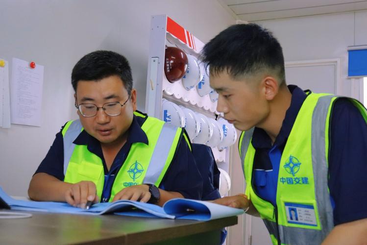 工厂新人指着图纸向老师傅提问
