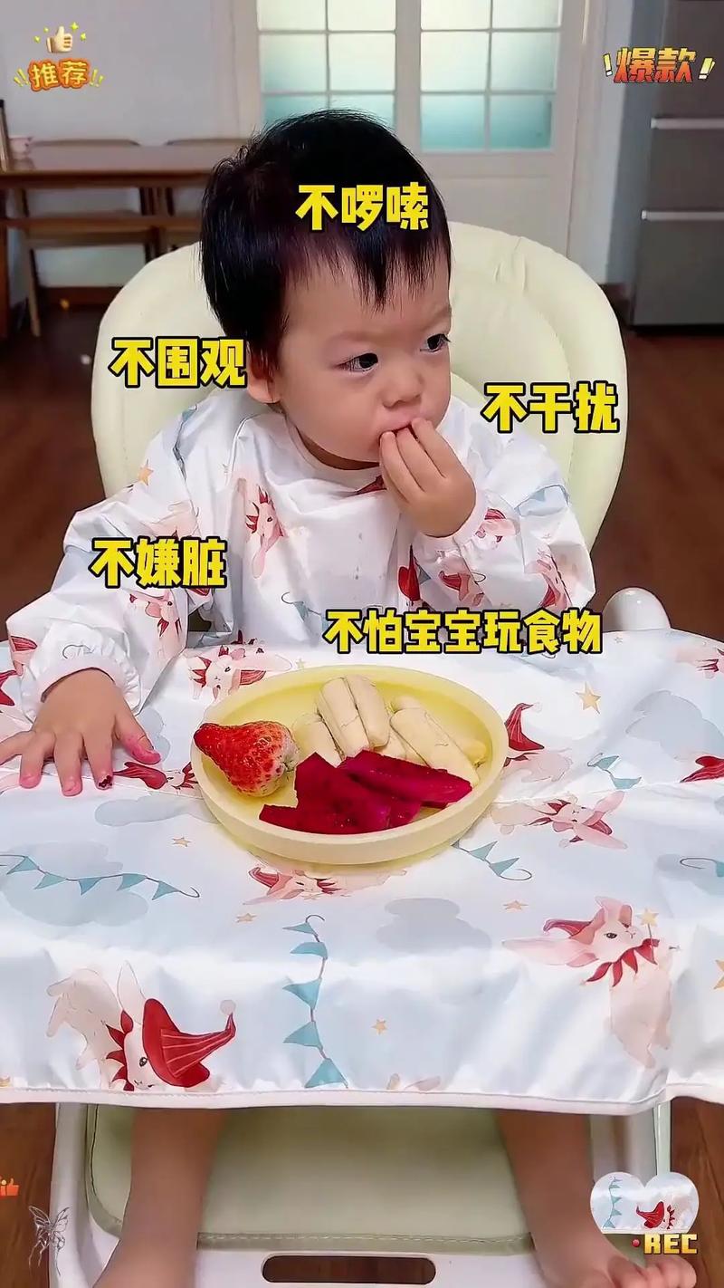 2岁幼儿自己选的明黄色罩衣坐在餐桌边吃饭