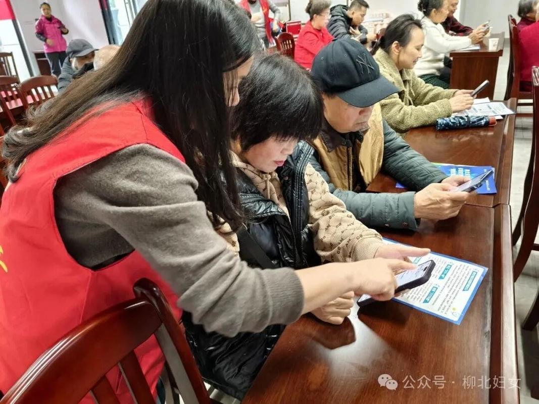 工作人员教老人用手机搜索就业援助小程序