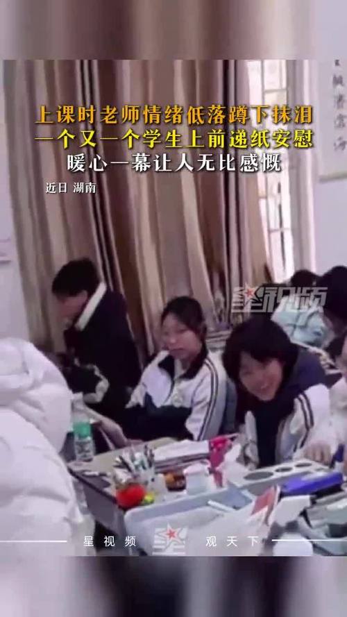 小学老师蹲在桌边递纸巾给哭的女学生