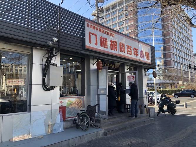 北京胡同藏在居民楼底层的老馆子门口