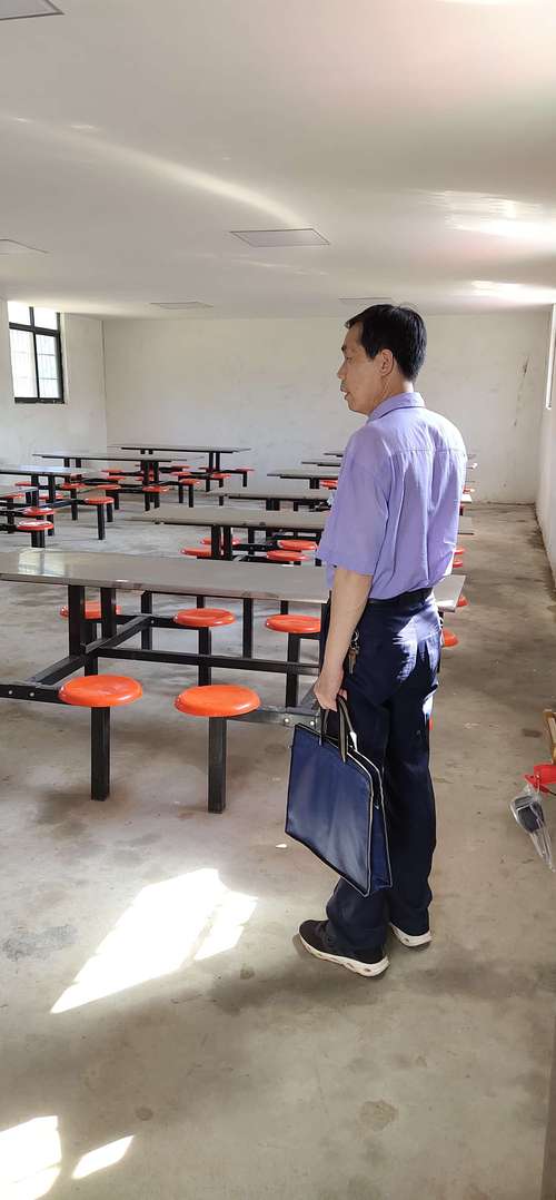 中学校长蹲在走廊水泥台阶和老师分吃盒饭的实拍图