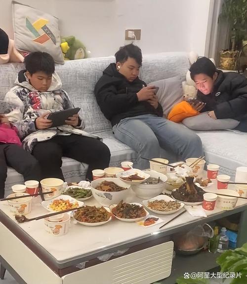 家庭晚餐家长孩子各自低头刷手机场景