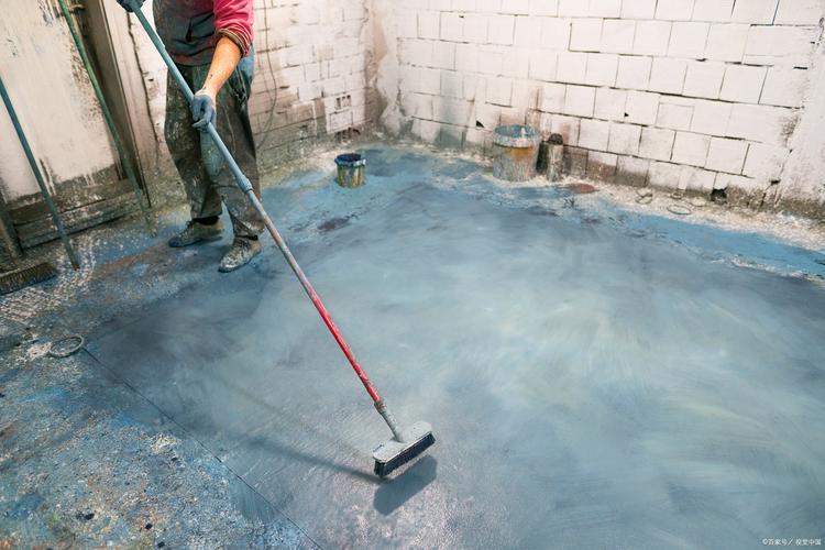 装修师傅用毛刷涂刷地面防水涂料特写