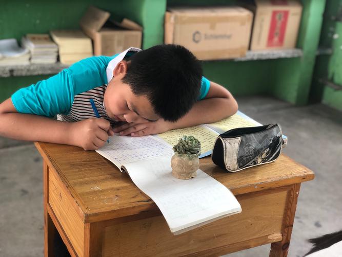 小学生趴在书桌前皱着眉抄错题的日常场景