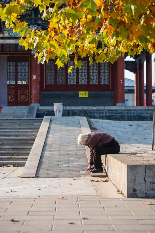 深秋董子读书台石质台基上晨练的老人